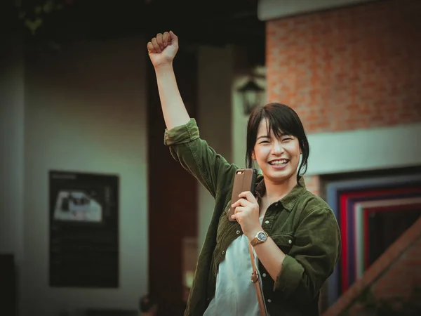 Asiatisk kvinna använda smartphone med glad stämning i köpcentrum — Stockfoto