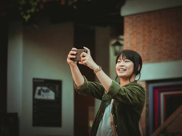 Mulher asiática usando smartphone com humor feliz no shopping — Fotografia de Stock