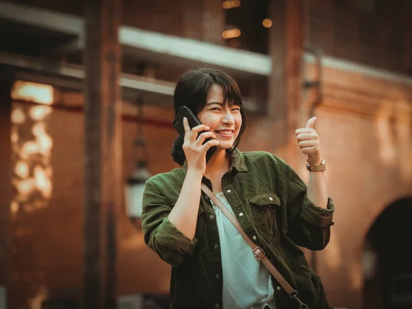 Asiatisk kvinna använda smartphone med glad stämning i köpcentrum — Stockfoto