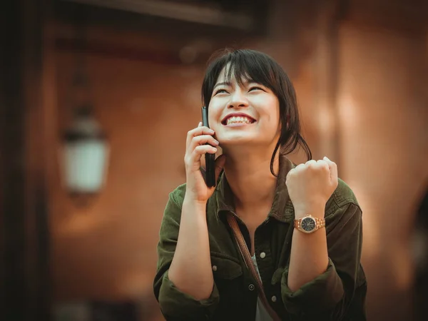 Asiatisk kvinna använda smartphone med glad stämning i köpcentrum — Stockfoto