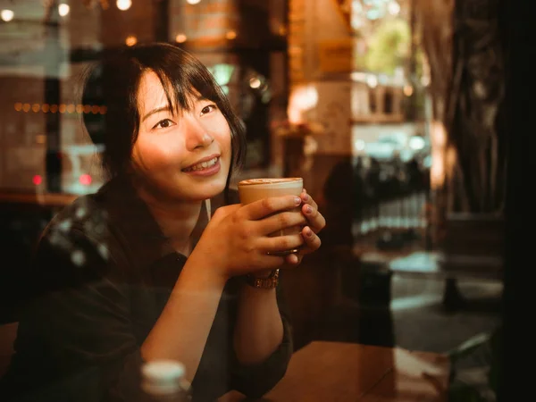 Asiatisk kvinna dricka kaffe i kaféet café — Stockfoto