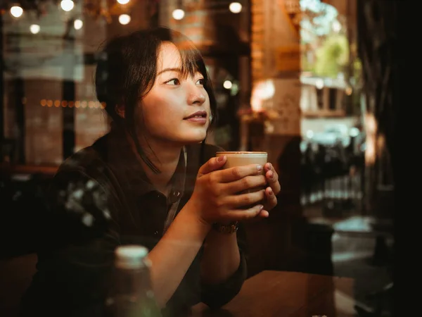 Asiatisk kvinna dricka kaffe i kaféet café — Stockfoto