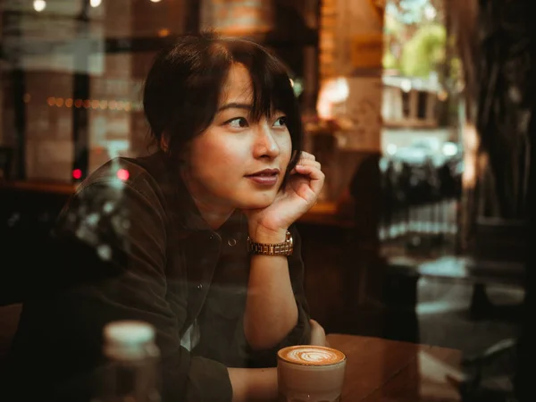 Asiatisk kvinna dricka kaffe i kaféet café — Stockfoto