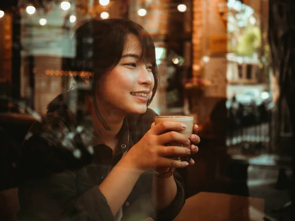 Азиатка пьет кофе в кафе — стоковое фото