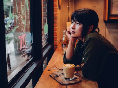 Asyalı kadın kahve dükkanı kafede kahve içme  