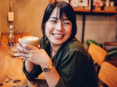 Asyalı kadın kahve dükkanı kafede kahve içme  