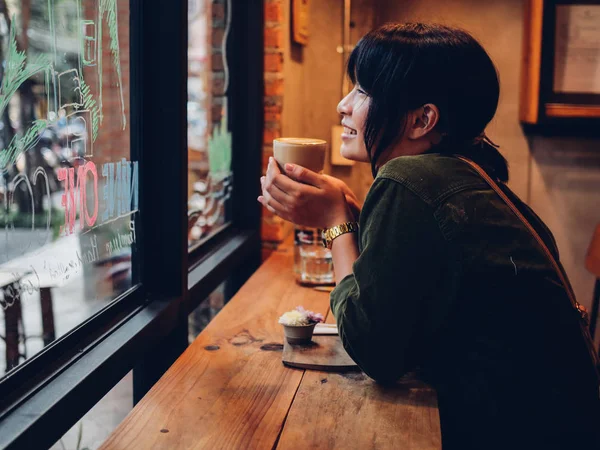 Asiatisk kvinna dricka kaffe i kaféet café — Stockfoto