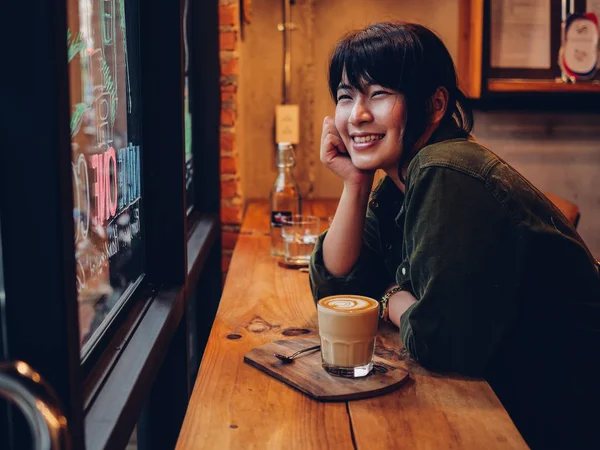 Азиатка пьет кофе в кафе — стоковое фото