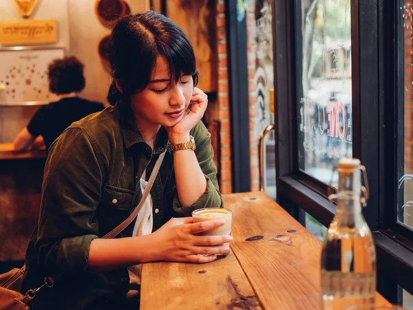 Asiatisk kvinna dricka kaffe i kaféet café — Stockfoto