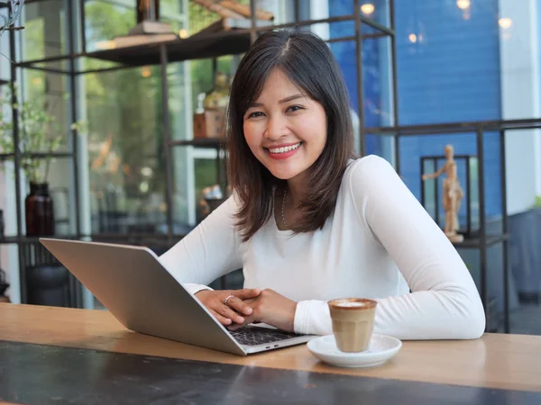 Asyalı kadın kahve dükkanı kafede bilgisayar dizüstü kullanarak — Stok fotoğraf