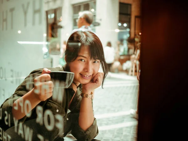 Kafede kahve içen Asyalı kadın. — Stok fotoğraf