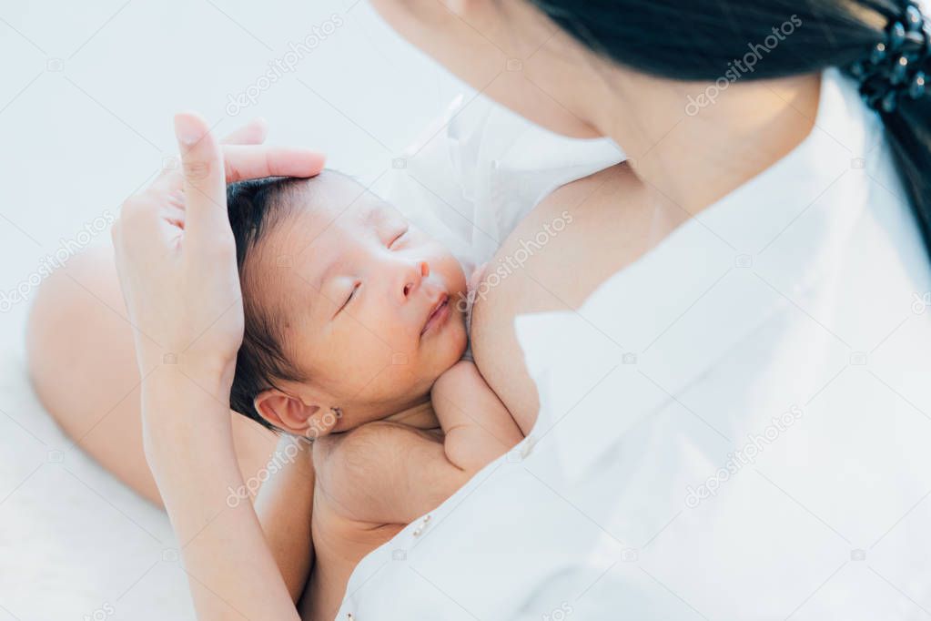 Asian newborn baby with mother concept : young mother breast fee