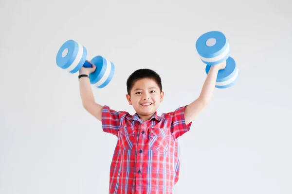 Азиатский мальчик с голубым цветом гантели на белом фоне — стоковое фото