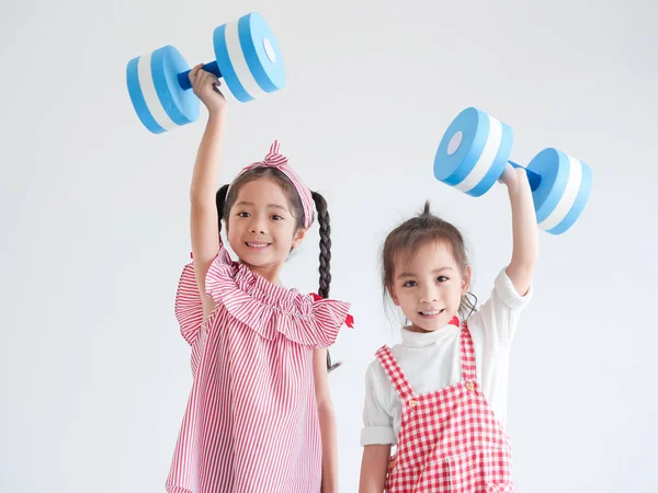 Menina asiática com haltere de cor azul no fundo branco — Fotografia de Stock