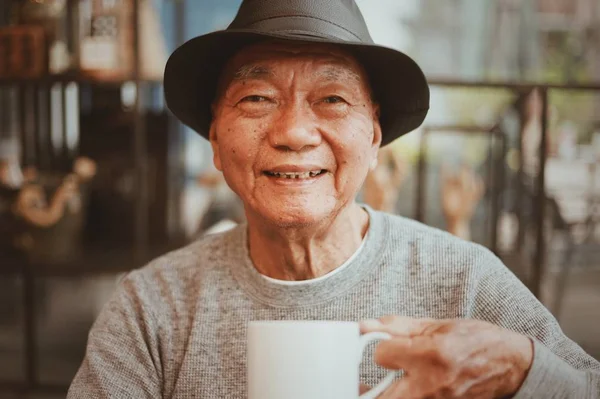 Asiatische senoir alter Mann Ruhestand Kaffee trinken im Café lächeln ein — Stockfoto