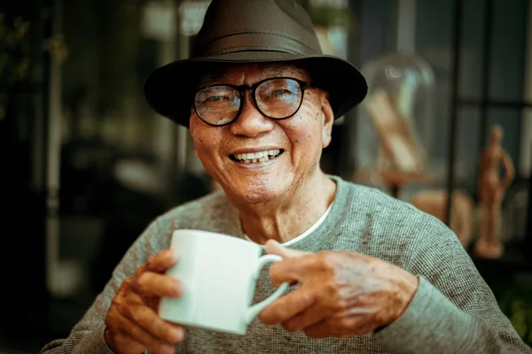 Азиатский сенуар старик на пенсии пить кофе в кафе улыбка — стоковое фото