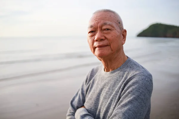 Portrait of Senior old man relax on the beach smile and happy fa