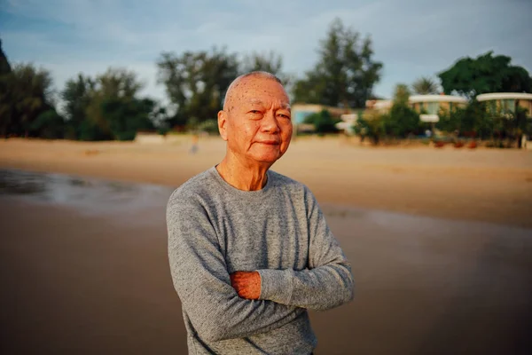 Портрет пожилого старика, отдыхающего на пляже, улыбается и счастлив — стоковое фото