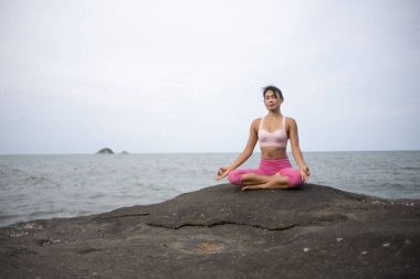 Sahilde Asyalı kız uygulama Yoga Sunrise sabah günü