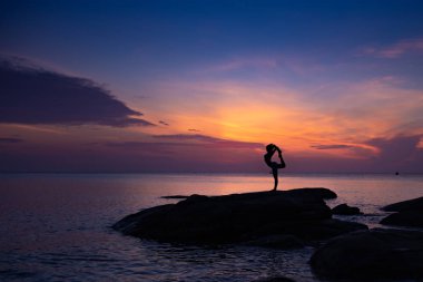 Sahilde Asyalı kız uygulama Yoga Sunrise sabah günü
