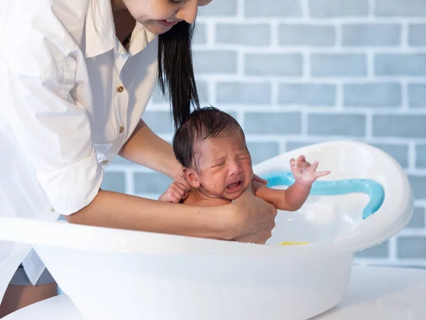 Mother bath Asian boy baby newborn on the bathtub