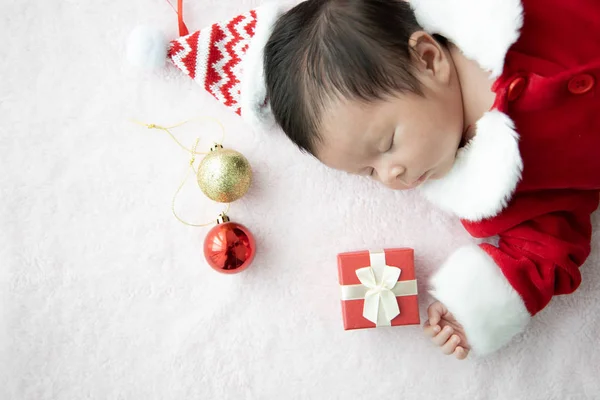 Asiatique bébé nouveau-né sur Santa claus uniforme dormir avec boîte rouge — Photo