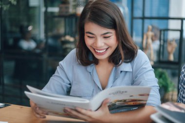 Kafede mavi gömlekli Asyalı kadın kahve içiyor ve konuşuyor w