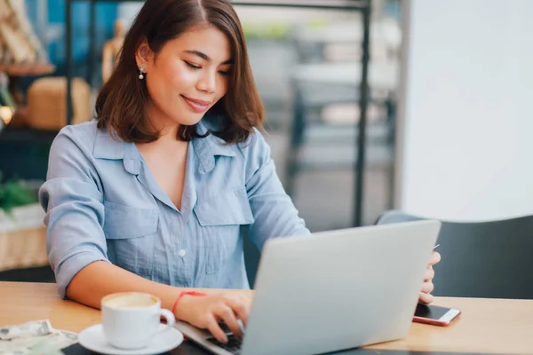 Asiatico donna in blu camicia in caffè bere caffè e utilizzando giro — Foto Stock