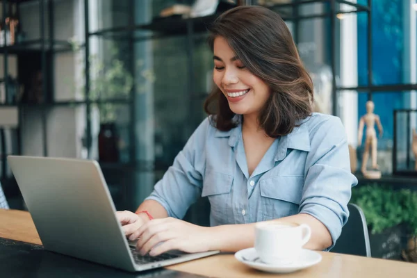 Asiatico donna in blu camicia in caffè bere caffè e utilizzando giro — Foto Stock