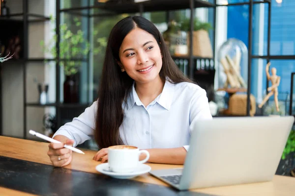 Asian woman in blue shirt working and drink coffee in coffee sho — Stock Photo, Image