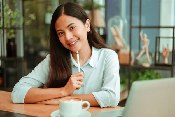 Asiatico donna in blu camicia lavoro e bere caffè in caffè sho — Foto Stock