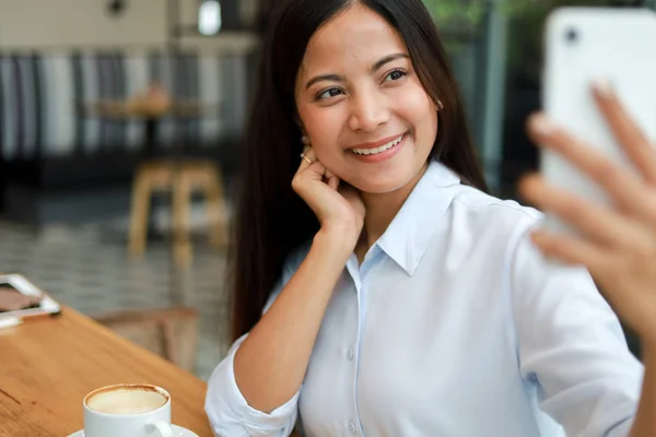 Asian woman selfie with mobile phone in coffee shop cafe smile a — Stock Photo, Image
