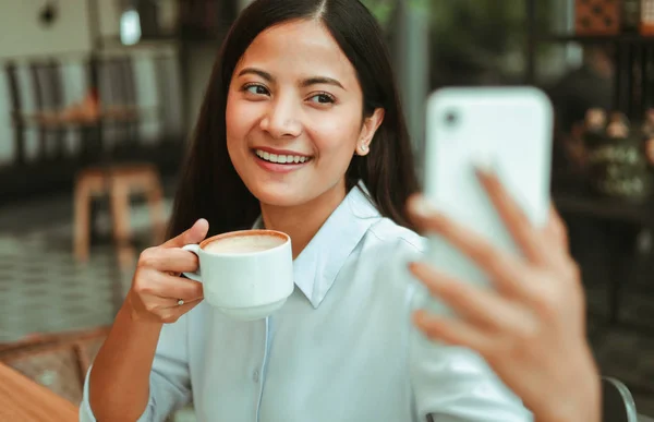 Asian woman selfie with mobile phone in coffee shop cafe smile a — Stock Photo, Image