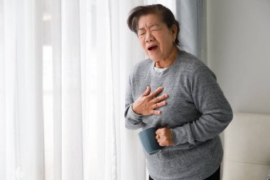 Asyalı yaşlı kadın anne oturma odasında kalp attact hasta 