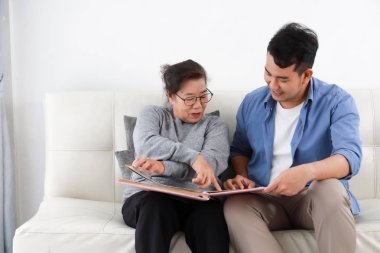 Mavi gömlekli Asyalı yaşlı kadın anne ve genç adam oğlu lookin