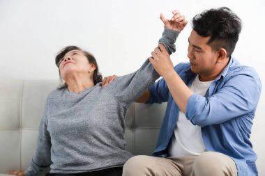 Mavi gömlek massag Asya kıdemli kadın anne ve genç adam oğlu