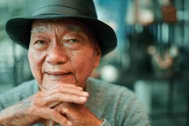 Asyalı yaşlı adam kafede kahve içen 