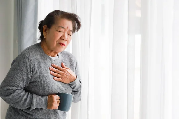 Asiatisk Senior kvinna mamma sjuk med hjärta attackera i vardagsrummet — Stockfoto