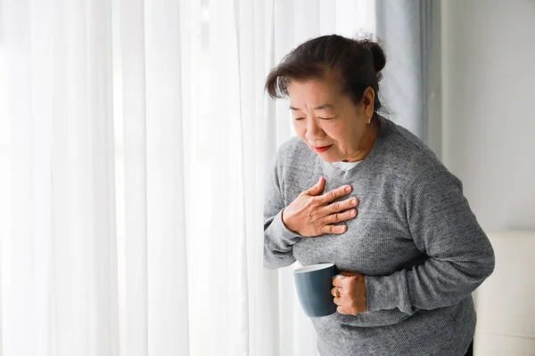 Ázsiai vezető nő anya beteg szívvel mechanizmusokkal a nappaliban — Stock Fotó