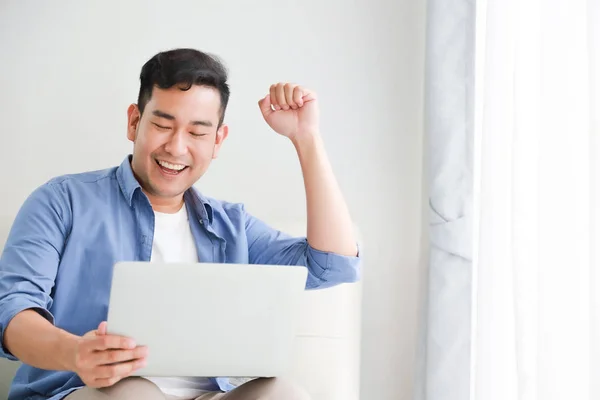 Asian handsome man working with laptop computer   in living room — Stock Photo, Image