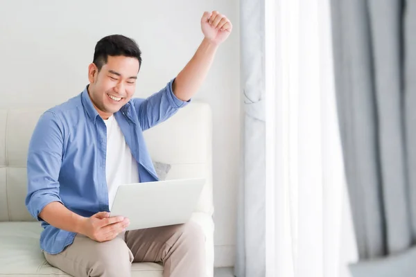 Asian handsome man working with laptop computer   in living room — Stock Photo, Image