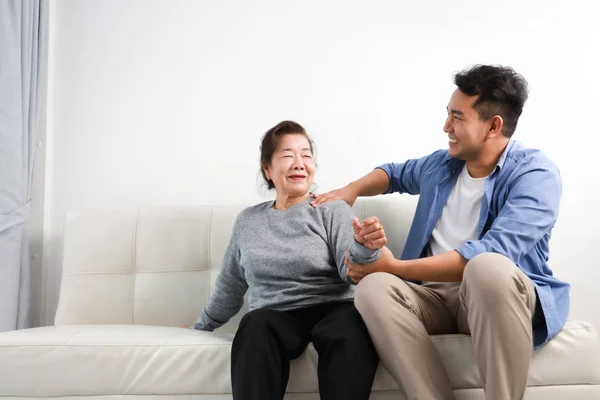 Asiática senior mujer madre y joven hombre hijo en azul camisa massag — Foto de Stock