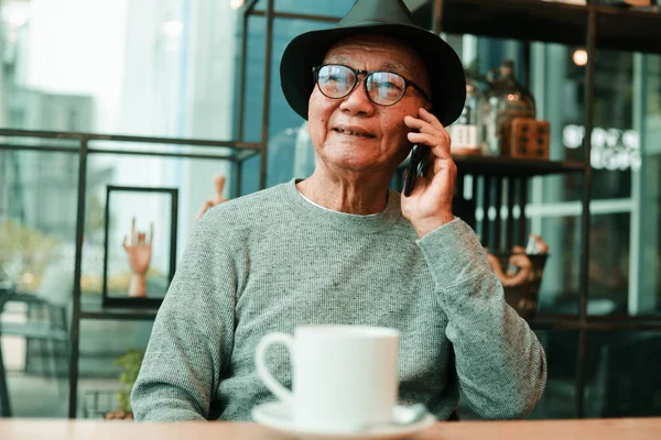 Asiatischer Senior trinkt Kaffee im Café eines Cafés — Stockfoto