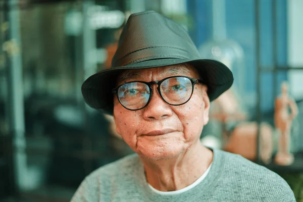 Азиатский пожилой человек пьет кофе в кафе — стоковое фото