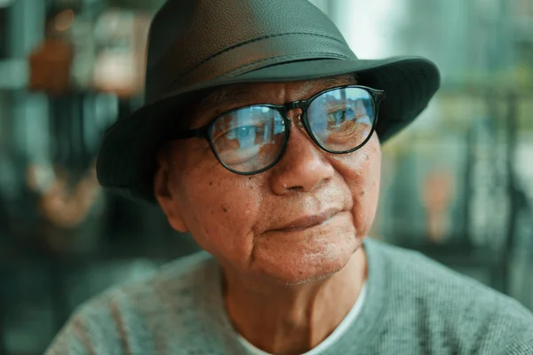 Asiatischer Senior trinkt Kaffee im Café eines Cafés — Stockfoto