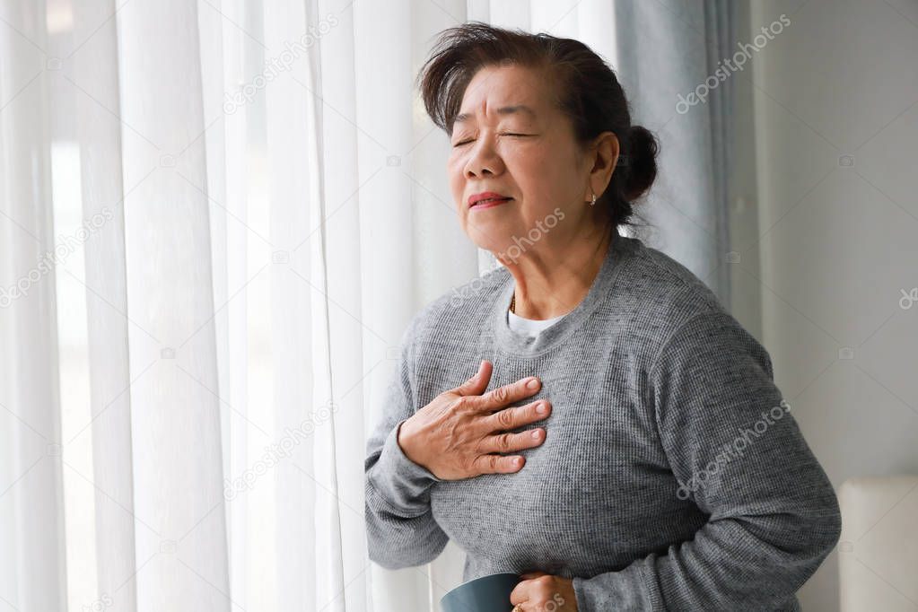 Asian senior woman mother sick with heart attact in living room 