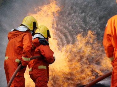 İtfaiyeci, yanan araba atölyesi yangın trenine su püskürttü.