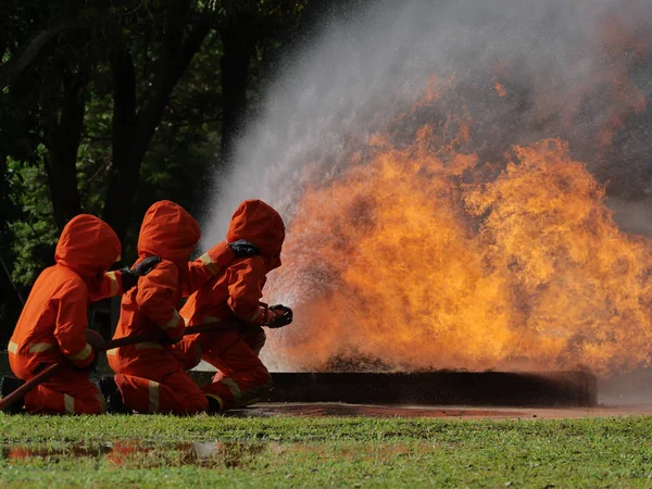 Bombero rociar agua para el fuego taller de coches en llamas fuego traini —  Fotos de Stock