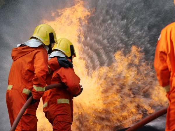 Firefighter spray water to fire burning car workshop fire traini — Stock Photo, Image
