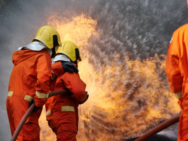 Firefighter spray water to fire burning car workshop fire traini — Stock Photo, Image